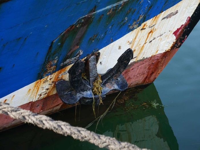 Close-up of rusty boat moored in water