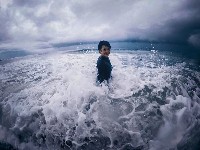 Portrait of boy in sea against sky