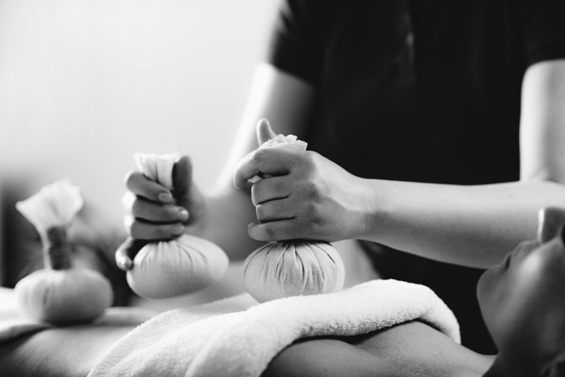 Kizhi massage or herbal bolus bags ayurveda massage, hands of an ayurveda massage therapist 