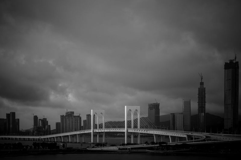 Bridge by buildings against sky in city