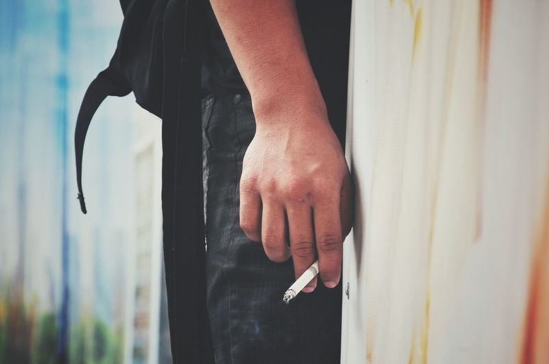 Midsection of man with cigarette 