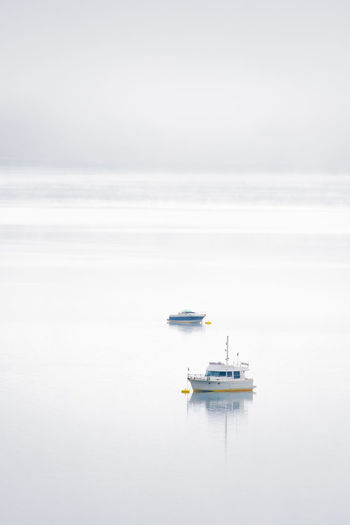 Peaceful scenery of modern boats floating on surface of calm river against cloudy sky in riano