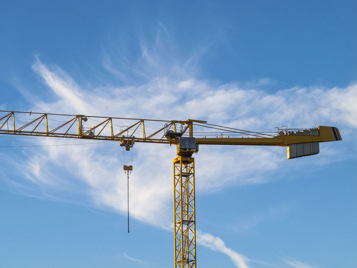 Low angle view of crane against sky