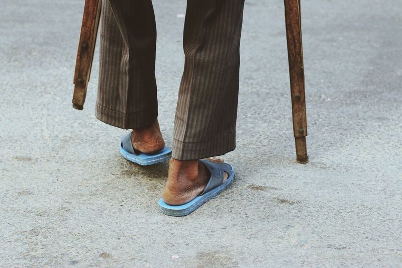 Low section of disabled man walking with crutches on street