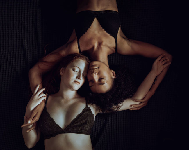 Top view of two young women caressing. lesbian gender diversity concept.