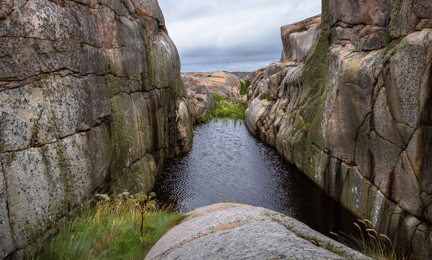 Canal amidst rocks against sky