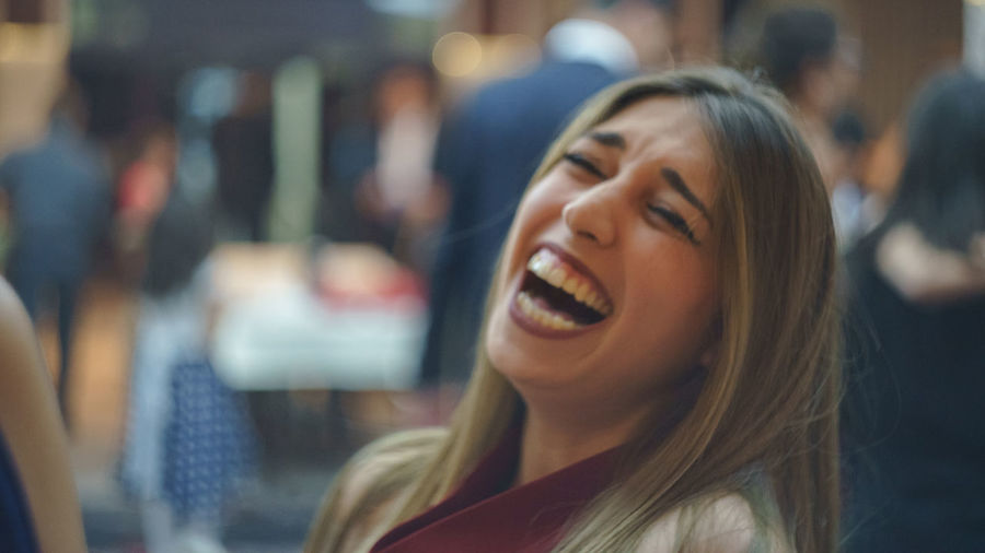 Young woman laughing while sitting at restaurant