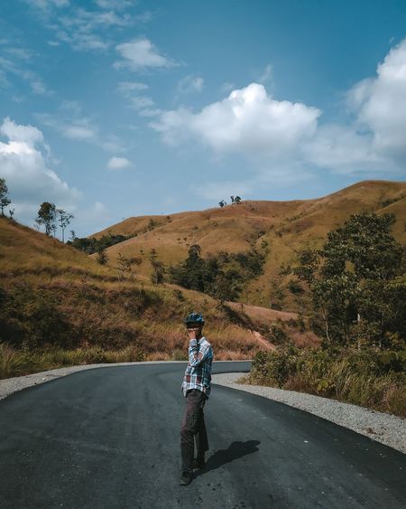 Men walking on road against sky