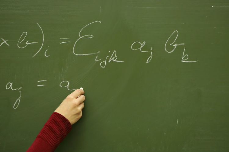 Physicist with equations on blackboard