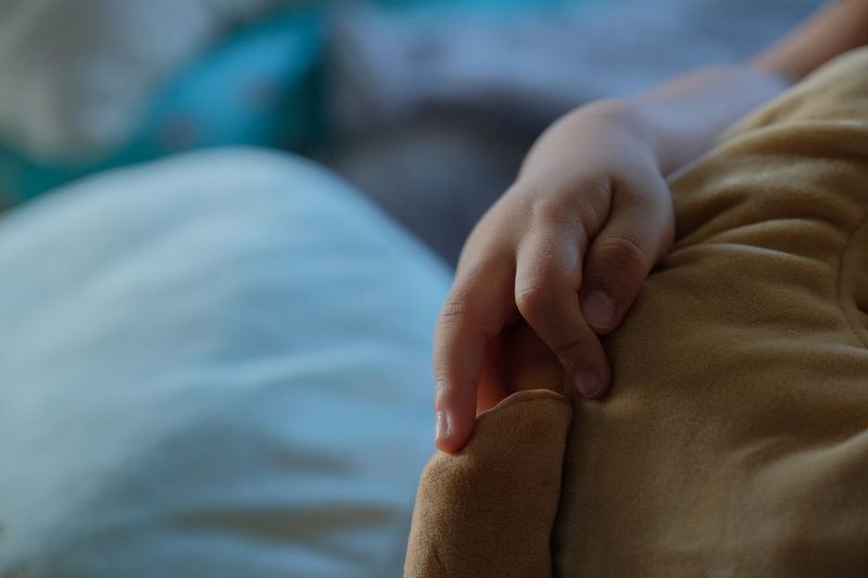 Cropped hand of child holding blanket