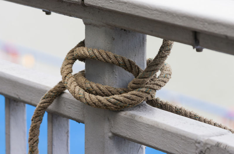 Close-up of rope tied on wooden railing