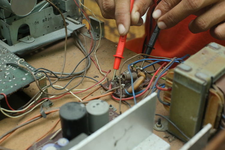 Cropped hands of male technician repairing radio