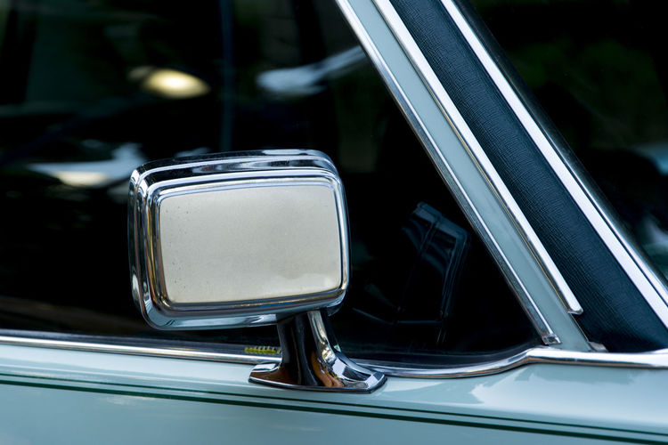 Detail of a cyan colored vintage car rearview mirror. salvador bahia brazil.
