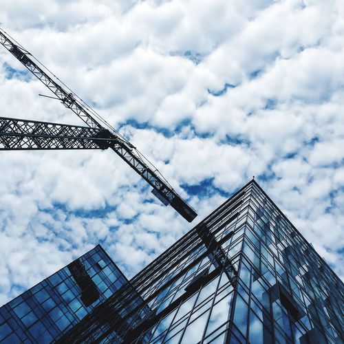 Low angle view of modern building against cloudy sky