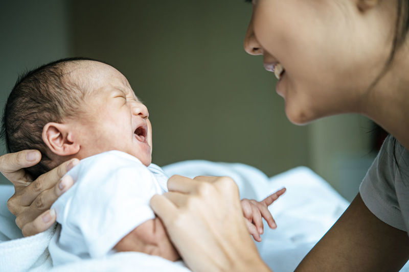 Close-up of mother holding baby at home