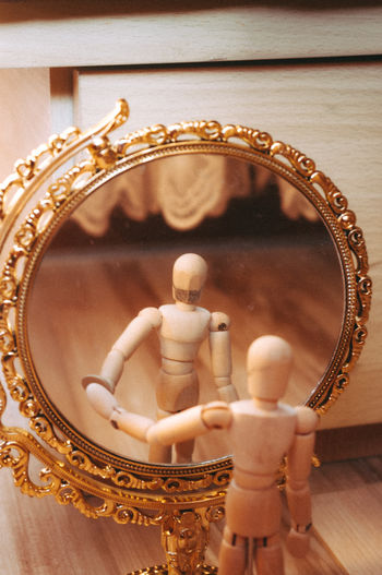 Close-up view of mirror reflection of figurine