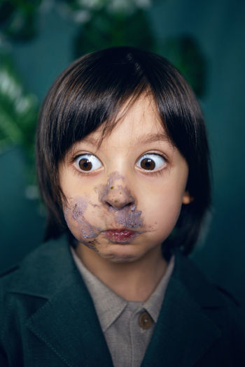 Portrait of baby boy smeared cake face