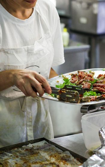 Midsection of man working in plate at restaurant