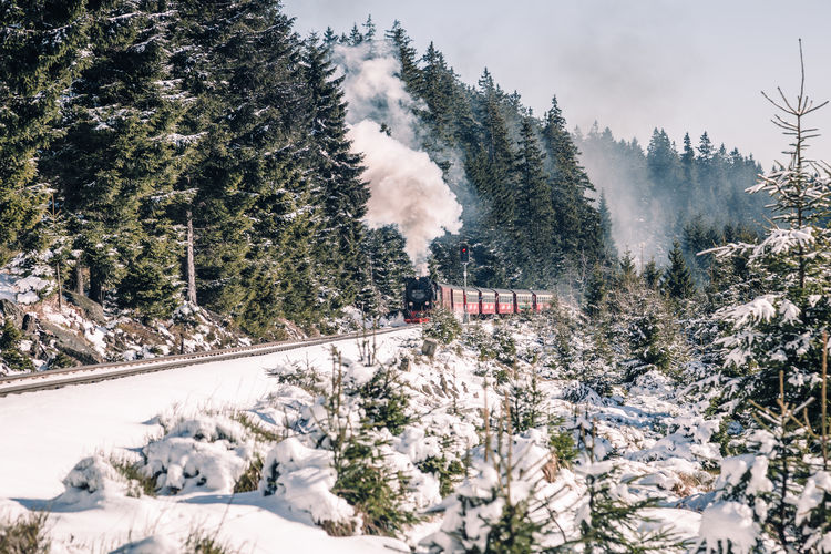 Steam train on railroad tracks during winter