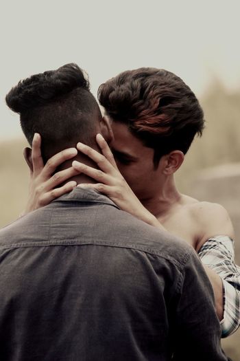 REAR VIEW OF MAN AND SON AT CAMERA