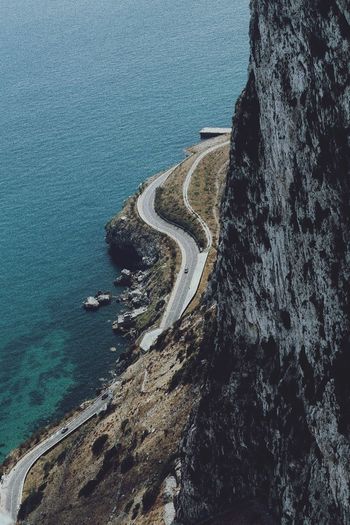 High angle view of winding road by sea