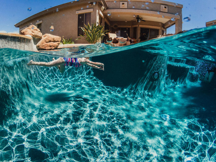 Girl swimming in backyard pool