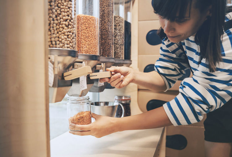 Customer filling jar with lentils in zero waste store