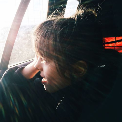 Close-up of girl looking through car window