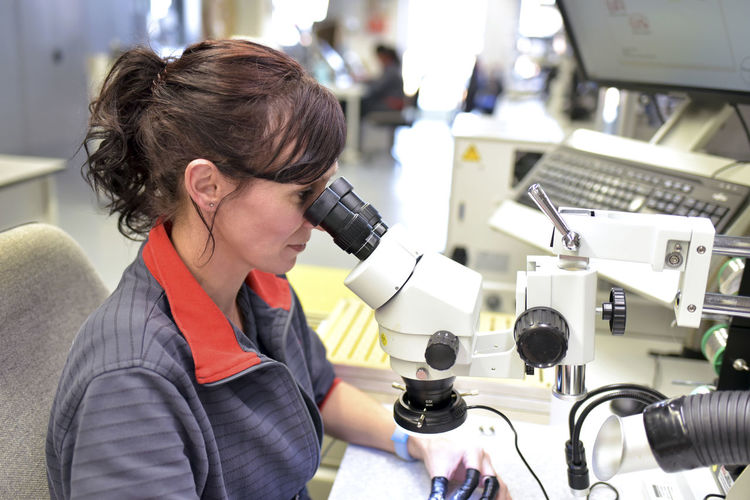 Side view of young woman working in laboratory
