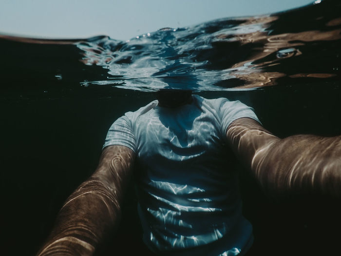 Man swimming in sea, underwater selfie