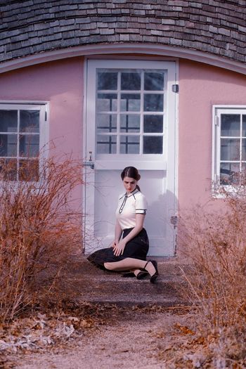 Young woman sitting against building