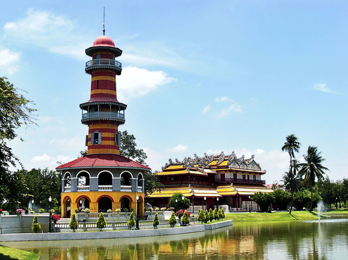 Lookout tower and bang pa-in royal palace by lake against sky