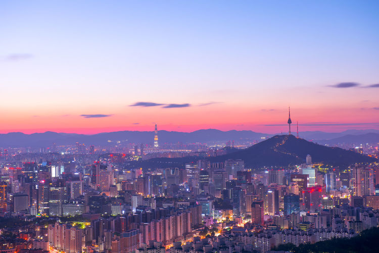 High angle view of city lit up at sunset