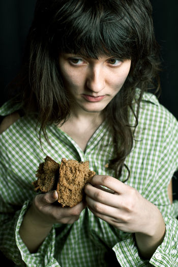 Homeless woman looking away while holding bread