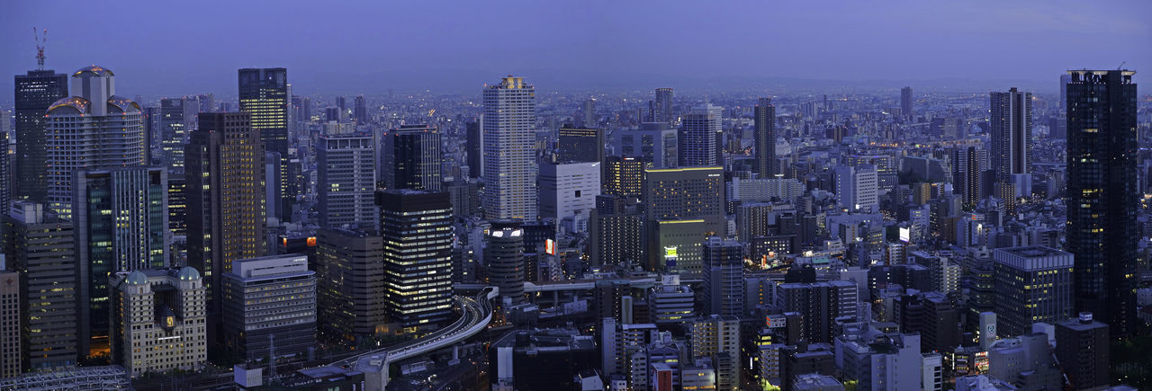 High angle view of city lit up against sky