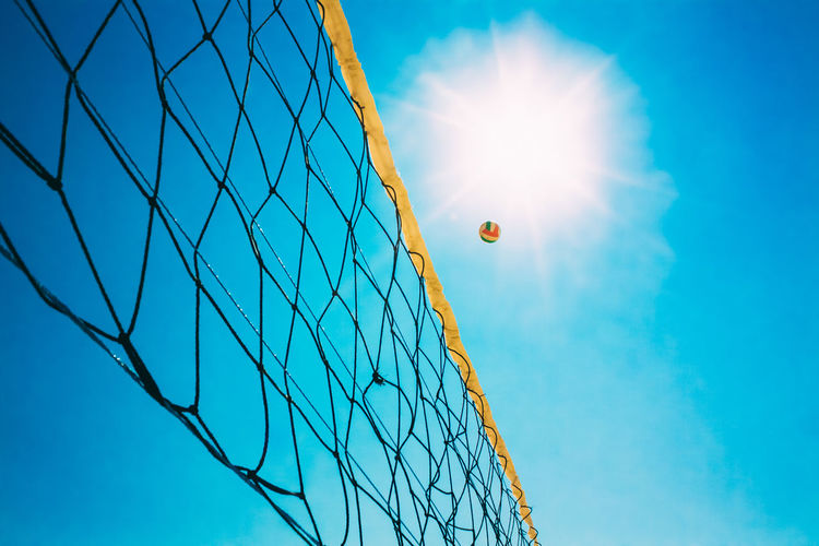 Low angle view of volleyball net against clear blue sky