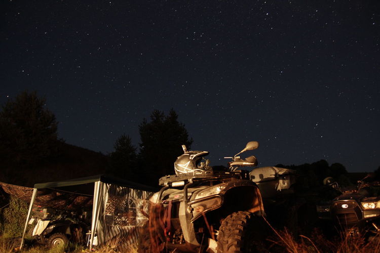Abandoned military vehicles against sky at night