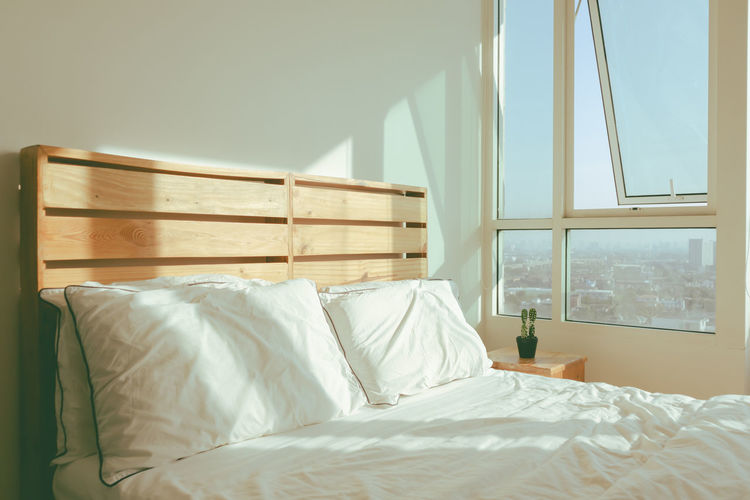 Loft white bedroom with soft sunlight of winter morning.