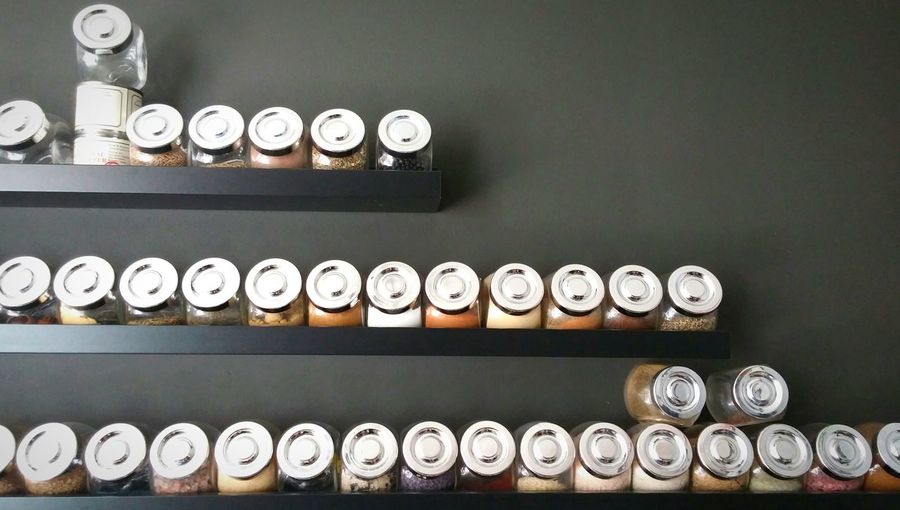 Jars of spices arranged on shelves at home
