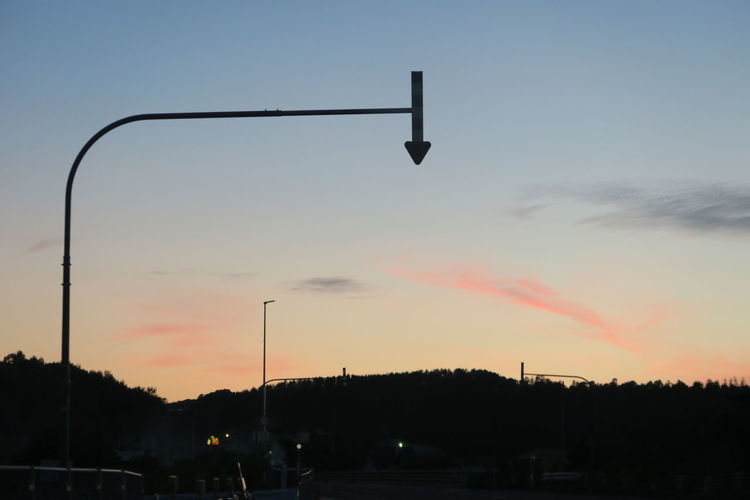Silhouette street light against sky at sunset