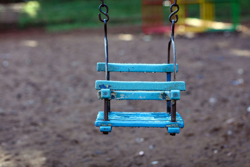 Empty baby swing hanging at playground