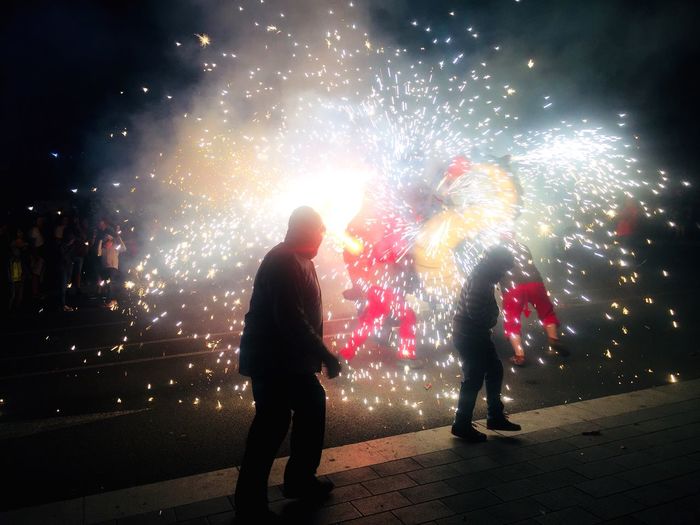 People enjoying firework display at night