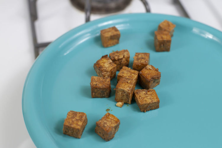 Nicely browned tofu cubes on a blue plate
