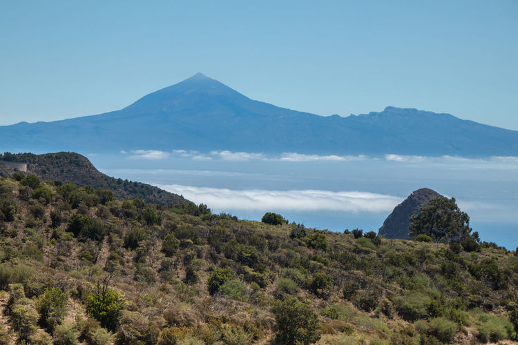 Scenic view of mountains against clear blue sky