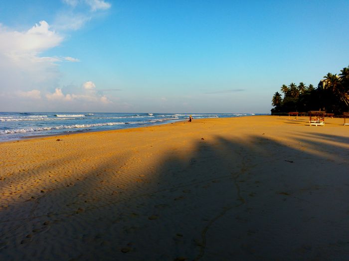 Scenic view of beach against blue sky