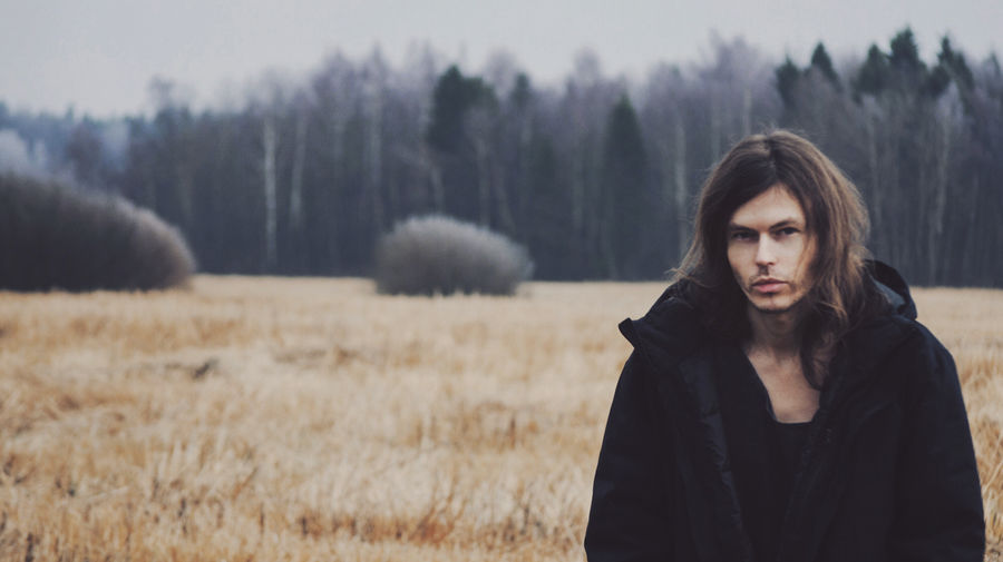 Portrait of man standing on field during winter