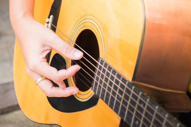 Midsection of person playing guitar