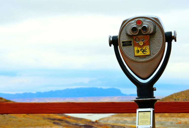 Close-up of coin operated binoculars facing landscape