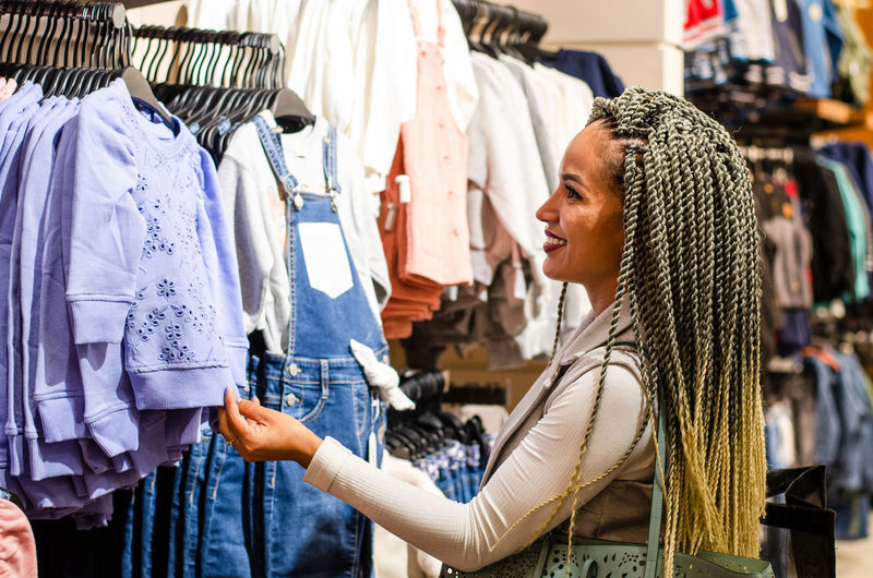 Side view of young woman standing in store