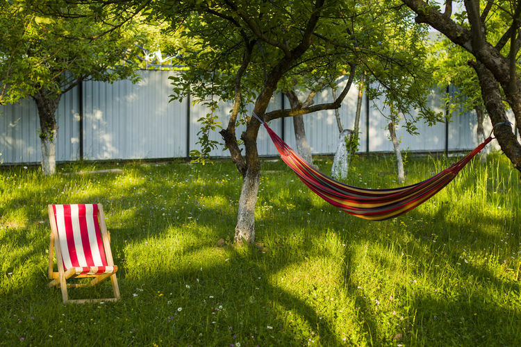 Yard chair on the grass and hammock, summer holiday background. copy paste space. 